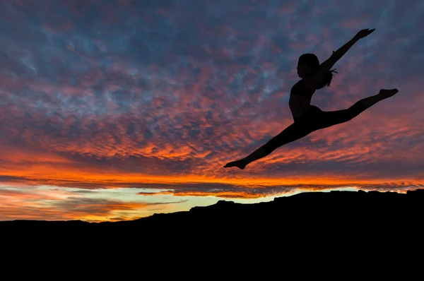 Σιλουέτα της γυναίκας που χορεύουν σε εξωτερικούς χώρους στο ηλιοβασίλεμα — Φωτογραφία Αρχείου