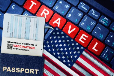 ABD 'nin pasaport, uçuş kartı, Amerikan bayrağı ve klavyede COVID-19 aşısı sertifikası bulunan yeni normal seyahat konsepti. Aşı pasaport kavramı.