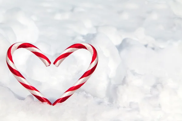 Cañas de caramelo en forma de corazón en la nieve — Foto de Stock