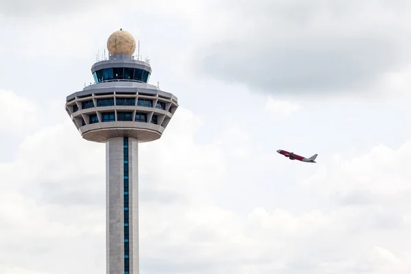Singapore Changi Airport Traffic Controller Tower with Plane Takeoff — стоковое фото
