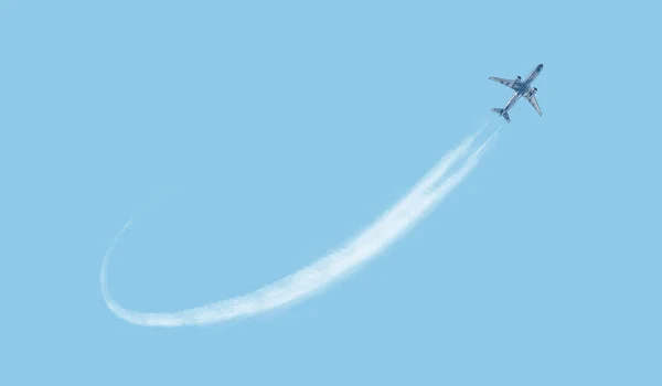 Avion volant dans le ciel, piste blanche dans le ciel depuis la buse de l'avion, illustration sur fond bleu — Photo