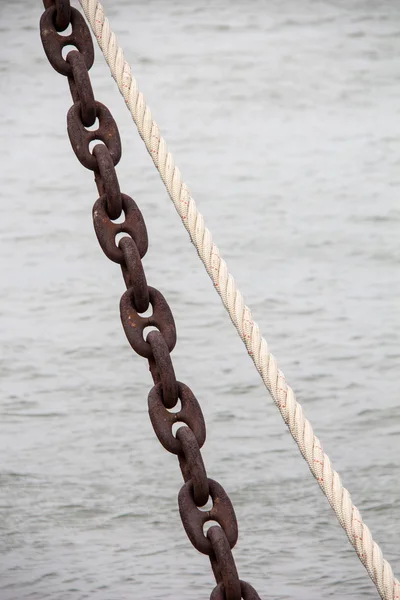 Ржавая цепь и металлическая веревка для швартовки — стоковое фото