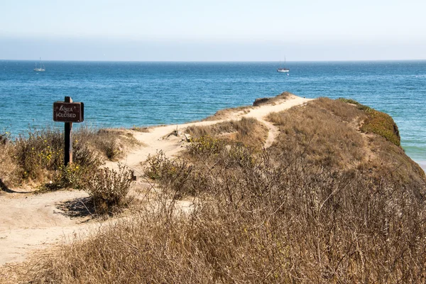 Wooden sign on sea shore — Stock Photo, Image