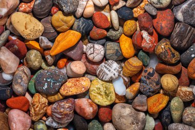 Renkli deniz taşlarının tam ekran dokusu berrak suda, üst görünümde.