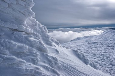 Bulutların üzerinde rime kaplı bir dağ sırtı