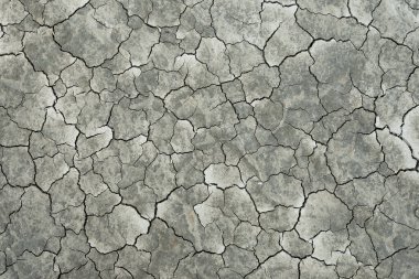 Çatlak toprağın tam ekran dokusu, üst görünüm.