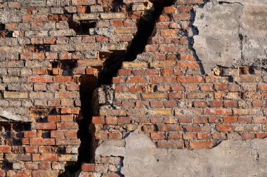 Büyük dikey çatlaklı eski bir tuğla duvar..