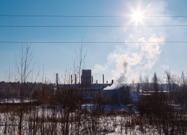 Orman Kış güneş günü boru kenarından duman ile fabrika görünümünü