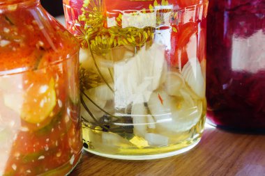 ahşap bir masa üzerinde konserve sebze birkaç kavanoz