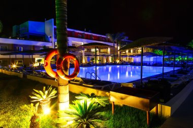 Yüzme Havuzu ve gece can simidi ön planda Palm'da otel