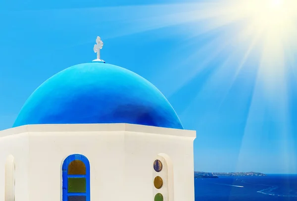 希腊Oia Santorini或Thira 在阳光明媚的日子里 可以看到正宗的教堂蓝色圆顶和房子的阳台 前面开着鲜花 后面是大海 右边角落阳光灿烂 — 图库照片