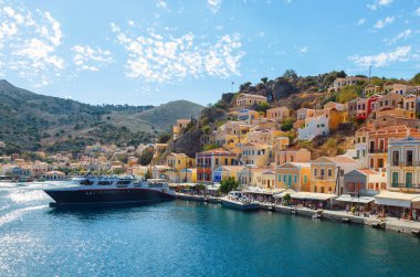 Symi Körfezi, gemileriyle ve bulutlu mavi gökyüzüyle