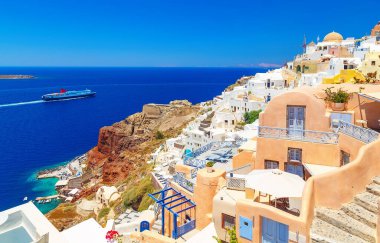 Ege Denizi 'ndeki geleneksel Yunan ada mimarisinin Oia köyünün nefes kesici manzarası ve öğlen güneşinin yansıması. Santorini Adası, Yunanistan, Avrupa.