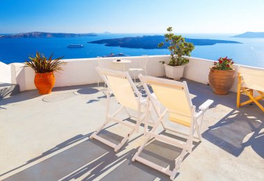 Otelin terasında güneşli yataklar. Santorini Adası, Yunanistan. Deniz manzaralı güzel yaz manzarası