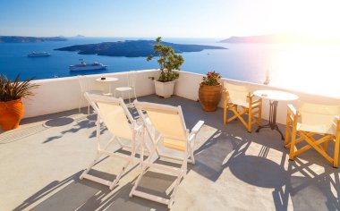 Yunanistan 'ın Santorini adasındaki terasta güneşli yataklar. Denizin güzel manzarası