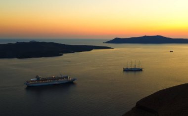 Günbatımında Santorini adasının yakınındaki körfezde Caldera 'ya bakan gemiler. Yunanistan
