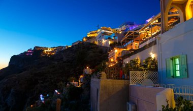 Greece Santorini island in Cyclades, wide view of white washed colorful houses at night clipart