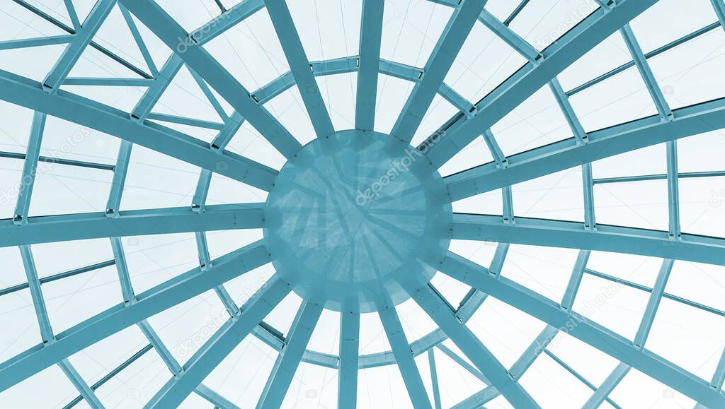 Glass dome of a modern building. View from the inside of the room. Light construction of transparent roof made of round steel tubes