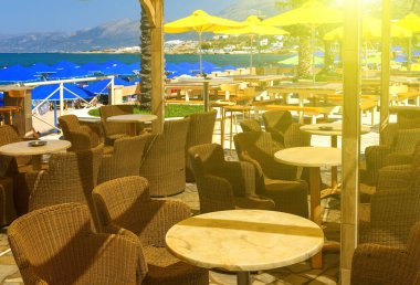 Sahilde, Yunanistan, Girit sahillerindeki boş bir kafede güneşli bir gün.