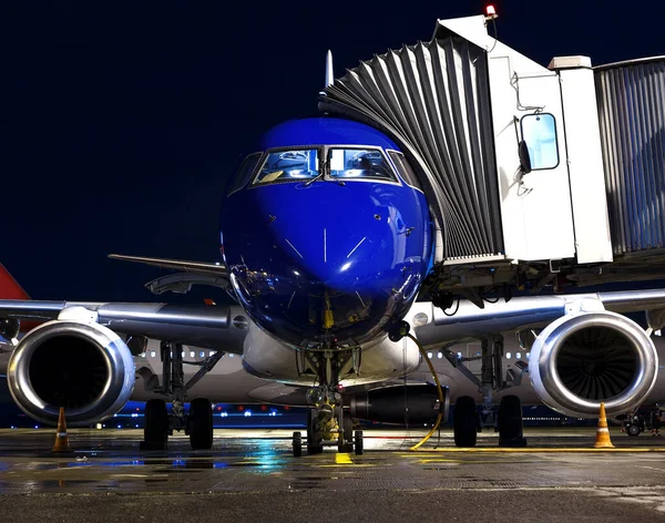Kék Repülőgép Egy Utas Alagúttal Ami Kapunál Parkol Éjszaka Egy — Stock Fotó