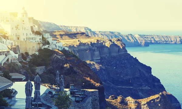 Image of white city on a slope of a hill at sunset, Oia, Santorini, Greece