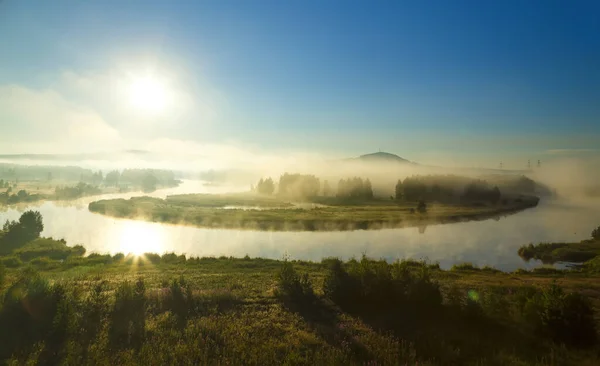 美丽的日出在雾蒙蒙的河雾早晨掠过 夏日的雾气和阳光笼罩着平静的河流 假日目的地 休息的地方 冥想状态 图库图片
