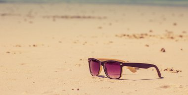 Güneş gözlükleri denize yakın bir plajda yatıyor.