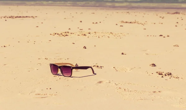 Солнечные очки лежат на пляже у моря — стоковое фото