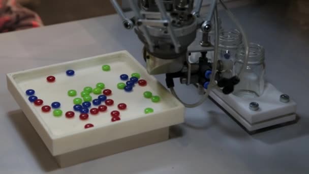 Robot scatters og folder i en krukke piller i forskellige farver – Stock-video