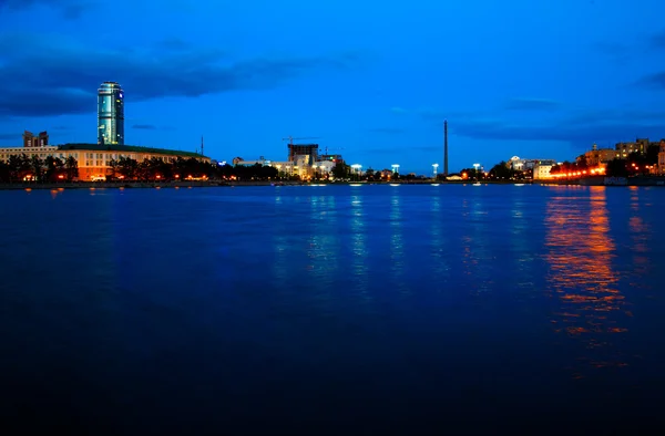 Stad bij nacht met gekleurde lampen zakelijke gebouw — Stockfoto