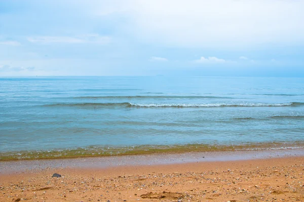Пляж со следами ног и спокойным морем — стоковое фото