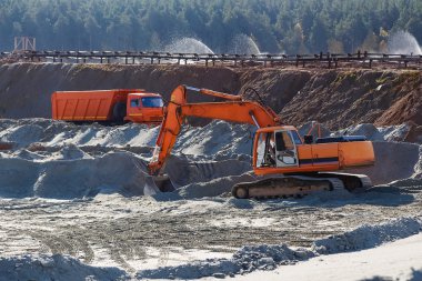 eksavator ve bir kamyon kum ocağında