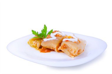 Lezzetli lahana dolması yemek beyaz tabakta ekşi krema ile doldurulmuş