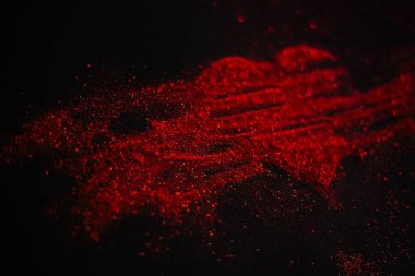 Scattered red heart made of sparkles on a black background. Shimmering dust symbol. Broken love concept clipart