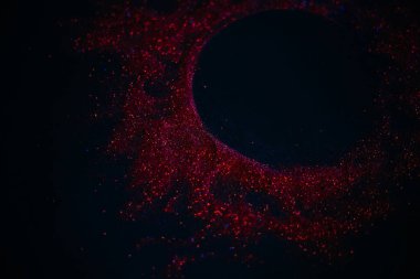 Pullardan yapılmış kırmızı güneş. Siyah arka planda dağınık pullar. Uzay dokusu. Parlayan kum