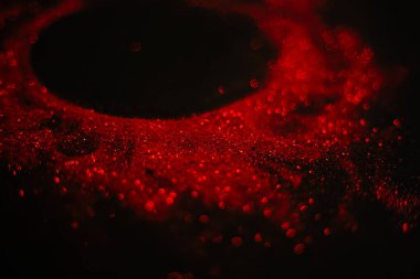 Pullardan yapılmış kırmızı güneş. Siyah arka planda dağınık pullar. Uzay dokusu. Parlayan kum