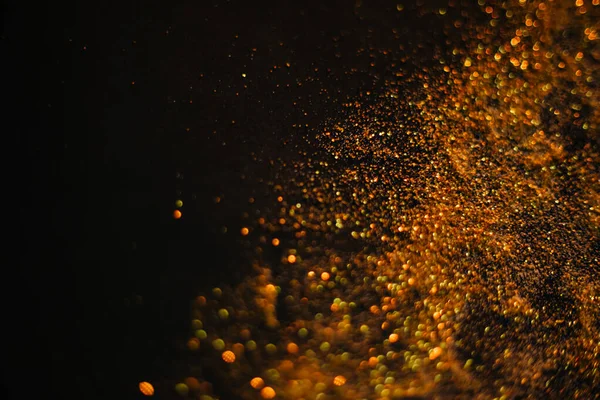 금빛 모래입니다. 검은 배경에 얼룩덜룩 한 반점들이 있다. blurred bokeh 배경 — 스톡 사진