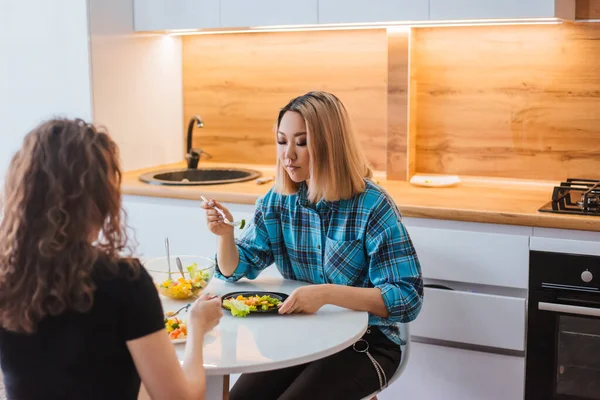 Dos Chicas Están Sentadas Mesa Cocina Comiendo Una Ensalada Dietética — Foto de Stock