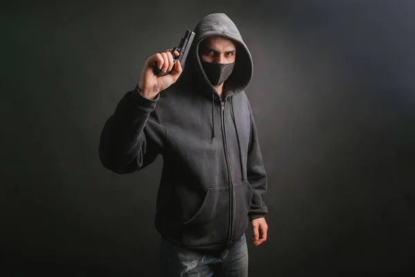 Gangster Kapuci Maska Drží Rukou Zbraň Tmavém Pozadí Bandita Míří — Stock fotografie