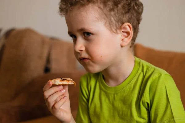 Chłopak Kręconymi Włosami Zieloną Koszulką Bierze Kawałek Pizzy Dziecko Domu — Zdjęcie stockowe
