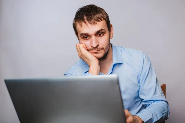 Mavi Gömlekli Genç Yakışıklı Bir Adam Bilgisayarın Başında Oturuyor Beyaz — Stok fotoğraf