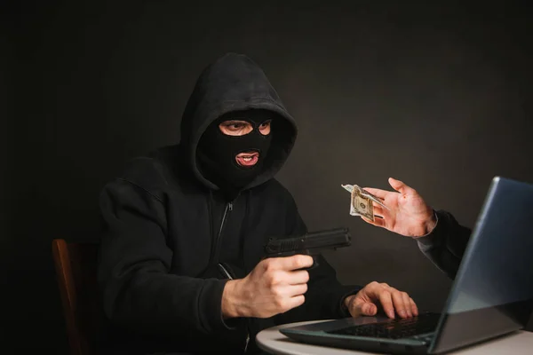 Egy Fekete Maszkos Pisztolyos Bűnöző Pénzt Lop Egy Laptopon Keresztül — Stock Fotó
