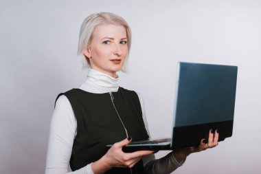 Elinde dizüstü bilgisayarı olan zeki bir kadın klavyeye yazı yazıyor. Beyaz arka planda sarışın.