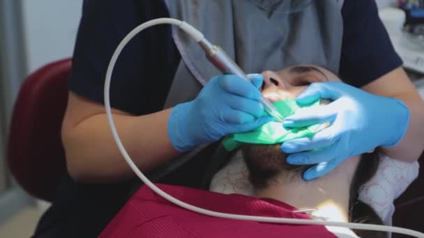 Der Zahnarzt untersucht die Zähne des Patienten mit einem speziellen Zahnspiegel. Der Typ beim Zahnarzttermin. Zahnbehandlung — Stockvideo