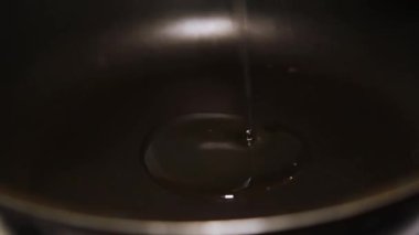 Rafine edilmiş sebze yağını siyah bir tavaya döker.