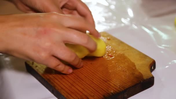 A womans hand is cutting green peppers into cubes on a wooden board. — Stock Video