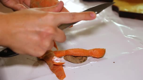 Ένα γυναικείο χέρι καθαρίζει ένα βρώμικο καρότο.. — Αρχείο Βίντεο