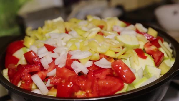 Ένα γυναικείο χέρι κλείνει το καπάκι σε ένα τηγάνι, τηγανίζοντας κολοκυθάκια και καρότα, ντομάτες, πιπεριές. Μαγειρεύω στο σπίτι. — Αρχείο Βίντεο