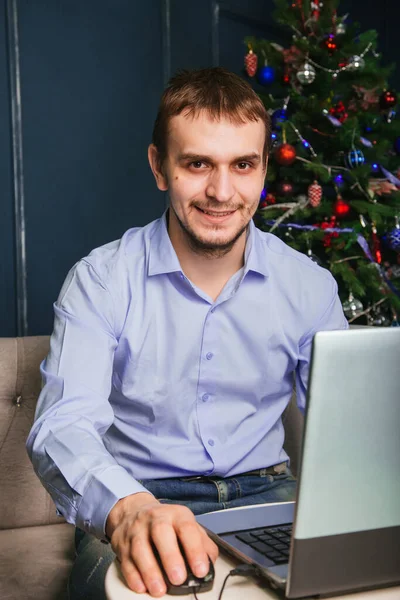 Guy Blue Shirt Sits Laptop Background New Year Tree Man — 스톡 사진