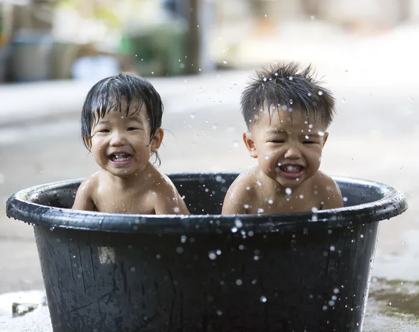 Twin brother and sister play and bath